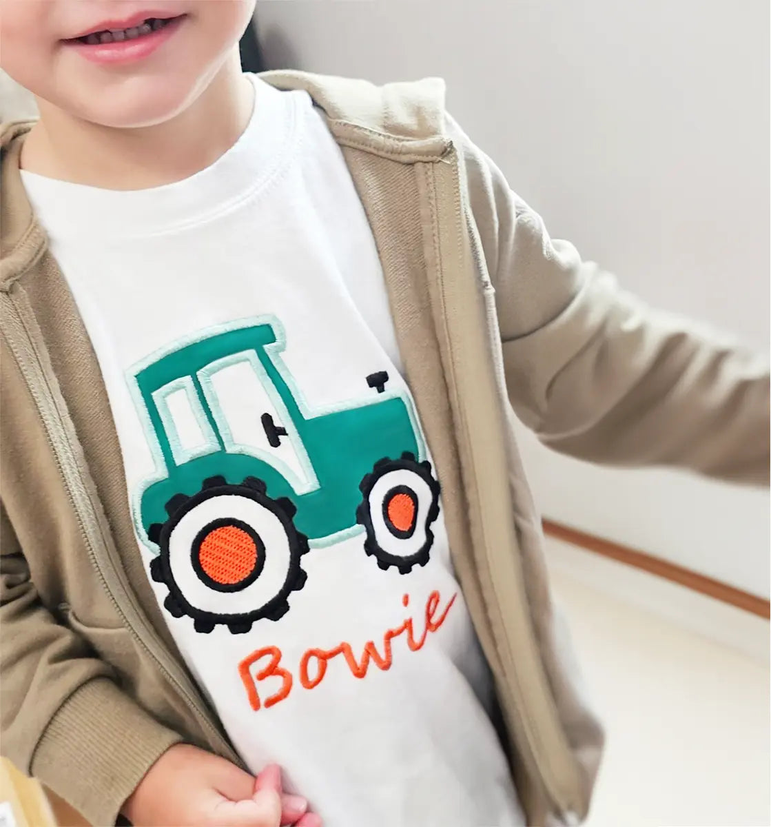 Smiling 3‑year‑old boy wearing a custom tractor‑themed embroidered T‑shirt – perfect gift idea for boys birthday