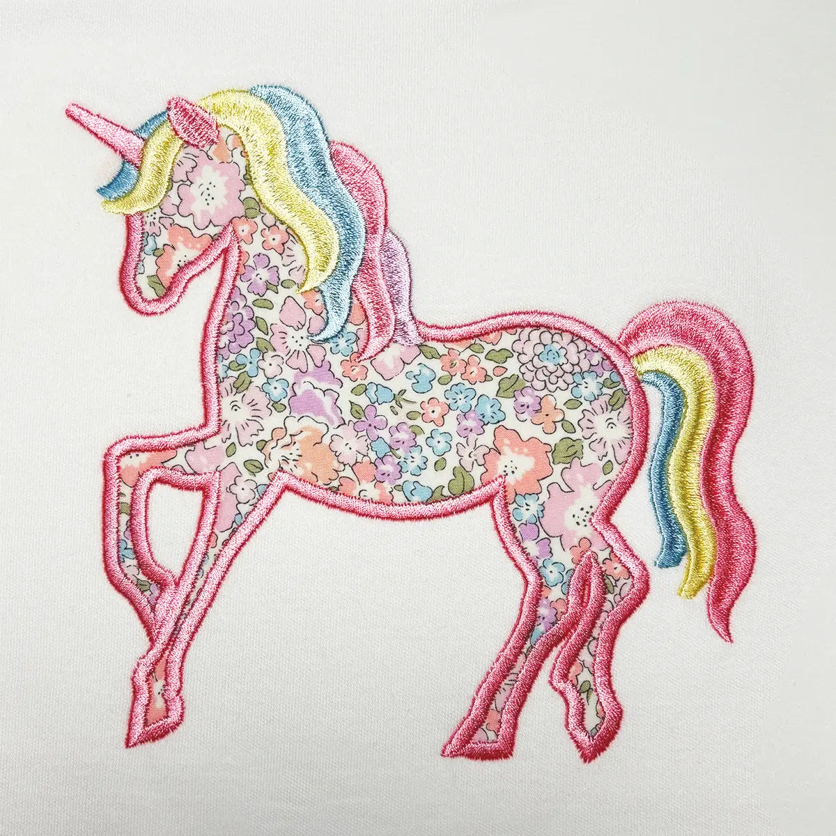 Close‑up of unicorn appliqué embroidery on a personalised girls T‑shirt – magical toddler gift